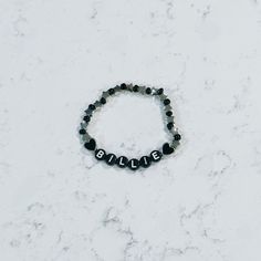 a black beaded bracelet with the word believe written on it