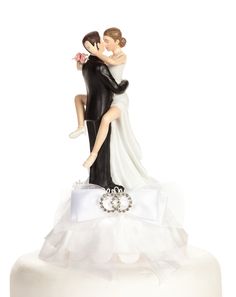 a bride and groom figurine on top of a wedding cake