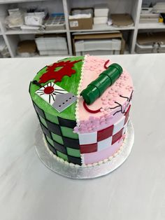 a cake decorated with different colored designs on a white counter top in a room full of shelves