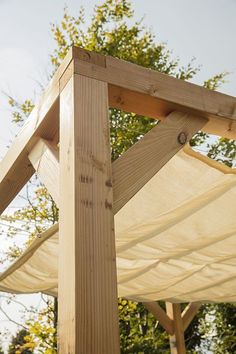 a wooden structure in the middle of a park with trees and sky in the background