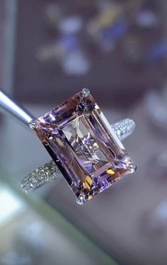 a fancy diamond ring being held by a tong