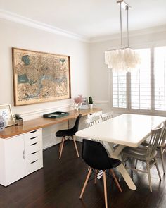 a dining room table and chairs in front of a window