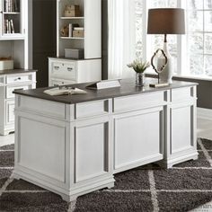 an office with white cabinets and black counter tops in front of a gray carpeted area