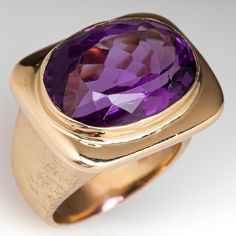 This vintage amethyst ring is centered with one (1) oval mixed cut natural amethyst set into a bright polished bezel setting. The tapered shank has a brushed finish. The ring measures 18.0mm at the top, rises 10.9mm above the finger, tapering to 4.7mm wide and 1.0mm thick at the base of the shank. It is currently a size 7.25. Luxury Amethyst Ring In Yellow Gold, Timeless Oval Purple Amethyst Ring, Timeless Purple Oval Amethyst Ring, Oval Amethyst Ring With Bezel Setting For Formal Occasions, Modern Oval Amethyst Ring With Polished Finish, Formal Amethyst Ring With Bezel Setting, Formal Purple Amethyst Ring With Bezel Setting, Vintage Amethyst Ring, Amethyst Ring Vintage