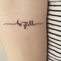 a woman's arm with the word be still tattooed on her left side ribcage