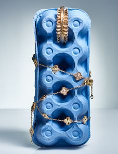 a blue case with gold chains and rings on it