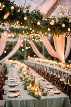 a long table with candles and greenery is set up for an outdoor wedding reception