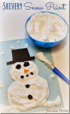 a snowman made out of foam sitting next to a bowl of white frosting