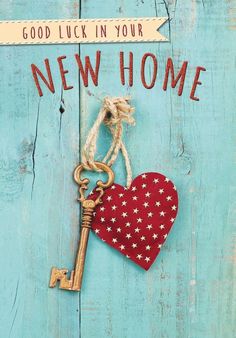 a heart shaped key hanging from a wooden door that says, good luck in your new home