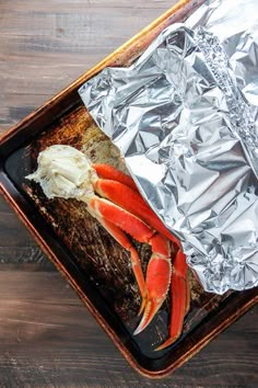 cooked crab legs in foil on a tray