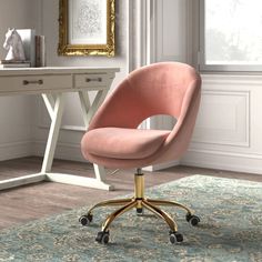 a pink chair sitting on top of a blue rug in front of a white desk