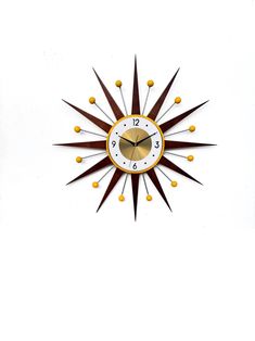 a clock that is on the side of a wall with brown and gold decorations around it