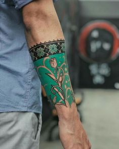 a man with a green and black tattoo on his arm