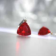 Introducing our exquisite red trillion-cut AAA quartz earrings, designed to captivate with their vibrant, fiery hue. Each gemstone features a brilliant red ruby quartz, complemented by a subtle gold hematite accent that adds a touch of warm sparkle. The stones are meticulously set to highlight their stunning clarity and rich color, making them the perfect statement pieces for any occasion. The earrings are elegantly suspended from modern, slightly hammered sterling silver ear wires, which lend a sleek and contemporary edge. These earrings blend delicate beauty with bold color, offering a chic and effortless way to add a pop of glamour to your look. Ideal for those who appreciate understated elegance with a hint of luxury. Quartz Trillions are 12mm  (Lab Created) Earrings measure about 1 an Party Red Gemstone Earrings, Red Sterling Silver Earrings For Evening, Red Sterling Silver Evening Earrings, Red Gemstone Earrings For Valentine's Day, Red Ruby Gemstone Earrings, Ruby Quartz, Silver Gold Earrings, Red Quartz, Color Making