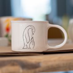 a white coffee cup with a drawing on it