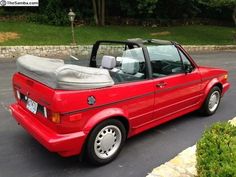 a red convertible car parked in a parking lot