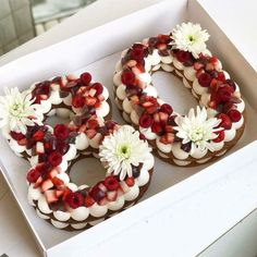 a box filled with donuts covered in fruit and white flowers on top of it