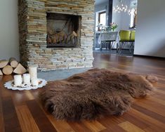 a living room filled with furniture and a fire place in the middle of it on top of a hard wood floor