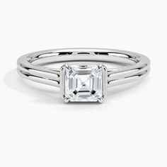 Asscher Cut Jade Trau Alure Solitaire Engagement Ring - 18K White Gold. Cathedral shoulders, a semi-bezel, and claw prongs create a classic solitaire silhouette in this modern yet timeless high polish ring. Crafted so other bands rest perfectly flush on the top or bottom, this design is made to be worn as part of a chic stack. 
 
 Jade Trau adds a signature spin on classic diamond staples, crafting designs timeless enough to evolve with you and unique enough to make a statement. Formal 14k White Gold Ring With Asscher Cut, White Gold Asscher Cut Jewelry With Center Stone, White Gold Asscher Cut Formal Jewelry, Asscher Cut White Gold Jewelry For Formal Occasions, Asscher Cut White Gold Formal Jewelry, Classic Emerald Cut Wedding Ring With Polished Finish, Classic Emerald Cut Jewelry With Bezel Setting, Asscher Cut Sterling Silver Diamond Ring For Formal Events, Classic White Gold Emerald Cut Jewelry