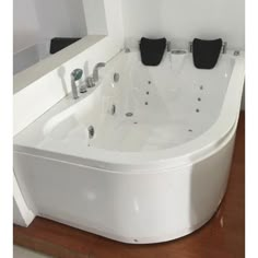 a large white bath tub sitting on top of a wooden floor