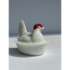 a ceramic chicken sitting in a white bowl