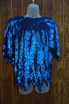 "Vintage size Medium blue and black beaded and sequined blouse. In good vintage condition.  Measurements taken across front laid flat 20\" across front armpit to armpit 25\" length 20\" across front of waist" Blue Embellished Party Blouse, Glamorous Blue Sequined Tops, Festive Blue Sequined Blouse, Blue Sequin Top For Party Season, Festive Blue Sequin Blouse, Blue Sequin Tops For Party Season, Festive Blue Blouse With Sequins, Blue Long Sleeve Sequin Top, Glamorous Blue Tops For Party Season