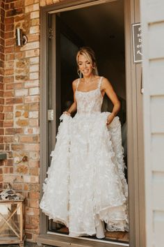 a woman in a wedding dress is standing outside the door