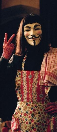 a person wearing a mask and holding up their hand