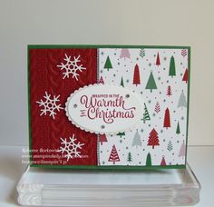 a close up of a christmas card with snowflakes and trees on the front