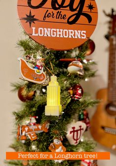 a christmas tree decorated with ornaments and an ornament that says, joy for the longhorns perfect for a longhorn tree