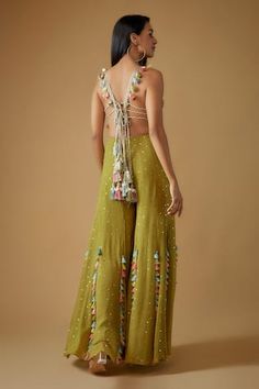 Olive green sleeveless halter neck back tie up choli with safari applique, beaded embroidery and tassel, cowrie embellishments. Paired with a mukaish and tassel embellished sharara. - Aza Fashions Festive Green Dress With Tassels, Festive Green Tassel Dress, Bohemian Sleeveless Sharara For Summer, Bohemian Green Sharara For Reception, Sleeveless Green Dress For Reception, Green Sleeveless Dress For Reception, Green Sharara For Summer Party, Green Summer Dresses For Reception, Green Summer Reception Dress