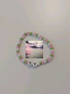 a pink and green beaded bracelet with a photo on it