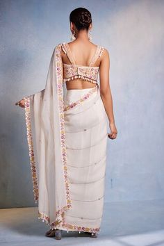 Off white padded blouse featuring floral hand embroidery all over with shell tassels on the waist hem. Paired with a hand embroidered pre-draped saree. - Aza Fashions White Blouse With Sheer Dupatta In Traditional Drape, Embroidered Draped Choli For Wedding, Wedding Embroidered Draped Choli, Embroidered Fitted Draped Saree, Wedding Blouse With Resham Embroidery And Draped Shape, Embroidered Fitted Saree, Sleeveless Pre-draped Saree With Intricate Embroidery, Wedding Blouse With Draped Resham Embroidery, Draped Wedding Blouse With Resham Embroidery