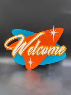 a sign that says welcome on the side of a metal surface with an orange and blue surfboard