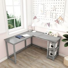 a computer desk sitting in front of a window next to a potted green plant