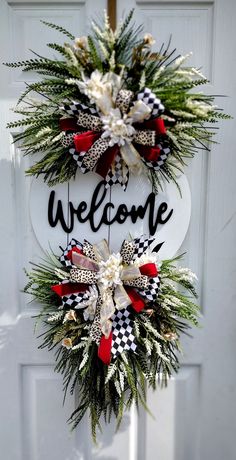 a welcome wreath hanging on the front door with red and white bow tie around it