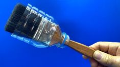 a hand holding a wooden brush over a blue background