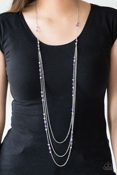 a woman wearing a black shirt and purple beads on her long silver chain necklace,