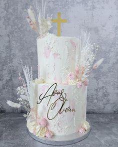 a wedding cake with white frosting and pink flowers