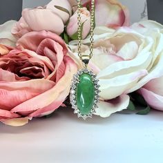 a close up of a necklace on a table with flowers and roses in the background