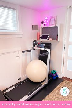 a room with a treadmill, exercise ball and computer on the desk in it