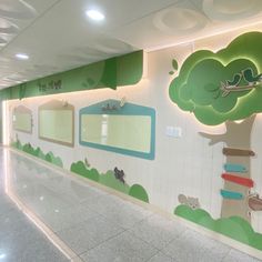 an empty hallway with trees and animals painted on the walls, along with mirrors in each corner