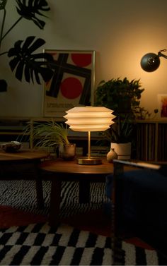 a living room filled with furniture and a lamp on top of a wooden coffee table