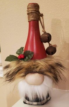 a gnome's head is sitting on top of a table next to a wine bottle