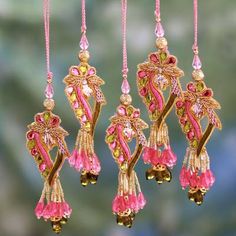 an assortment of pink and gold ornaments hanging from strings