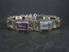 This gorgeous vintage bracelet is sterling silver with 6x10mm emerald cut gemstones and marcasites. It features 3 amethysts, 3 blue topaz and 2 citrines. Measurements: 1/2 of an inch wide - 6 1/2 wearable inches Weight: 24.9 grams Marks: 925, CL Condition: Excellent Classic Silver Multi-stone Gemstones, Vintage Silver Multi-stone Gemstones, Vintage Multi-stone Silver Gemstones, Silver Bracelets With Gemstone Accents For Formal Occasions, Formal Multi-stone Sterling Silver Bracelet, Inlay Jewelry, Marcasite Ring, Feather Ring, Garnet Earrings