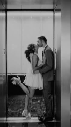 a man and woman kissing in an elevator