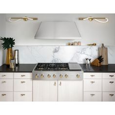 a stove top oven sitting inside of a kitchen next to white cabinets and counter tops