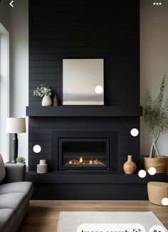 a living room with black walls and a fire place