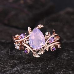 a ring with an amethorate and purple stones on it sitting on top of a